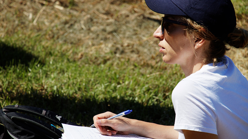 Regenerative Agriculture student in field taking notes