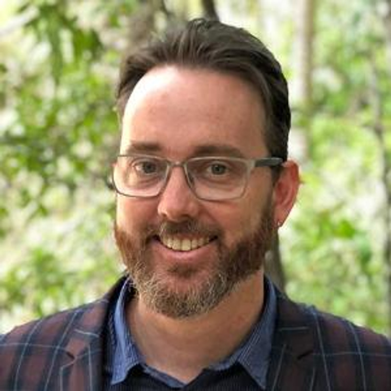 Man smiling with glasses and beard