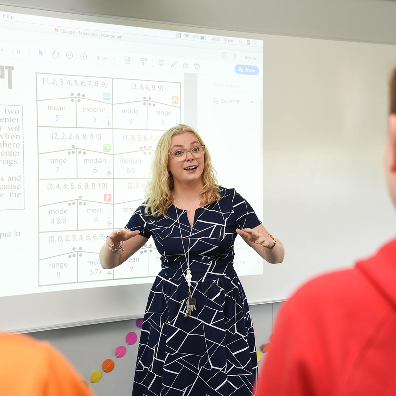 Female teacher with blonde hair teaching primary class
