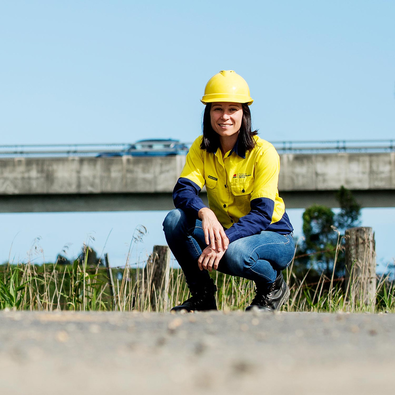 Female engineer wearing high vis with overpass in background