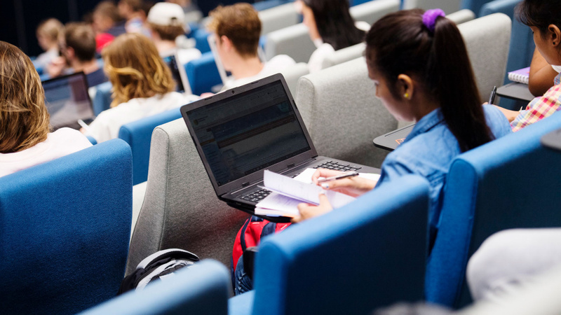 Student in auditorium with laptop
