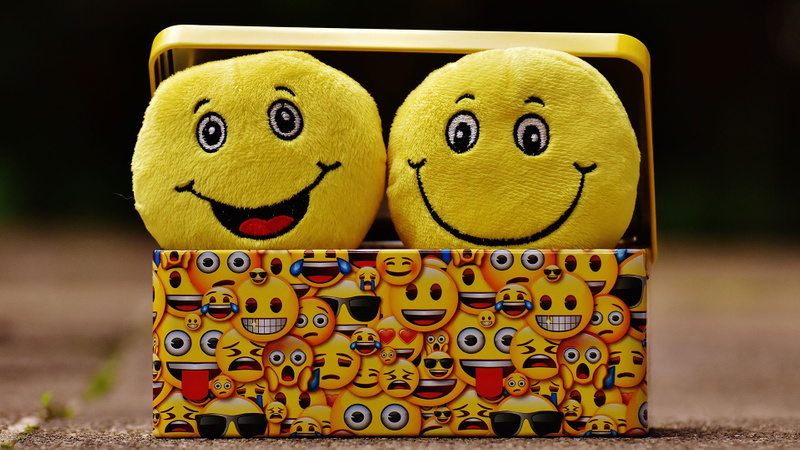 Box full of soft toys with smiling faces on them