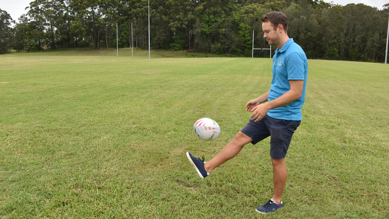 Christian Swann - Man kicking football on grassy sporting field