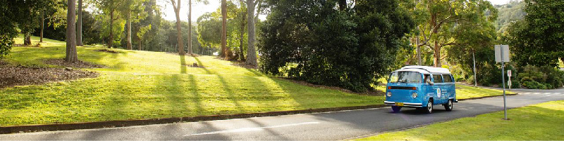SCU electric Kombi driving along a windy road surrounded by greenery