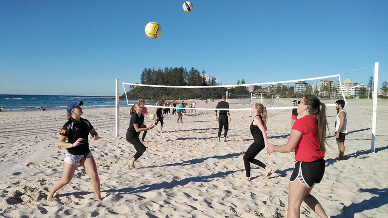 Students on beach practising volleyball