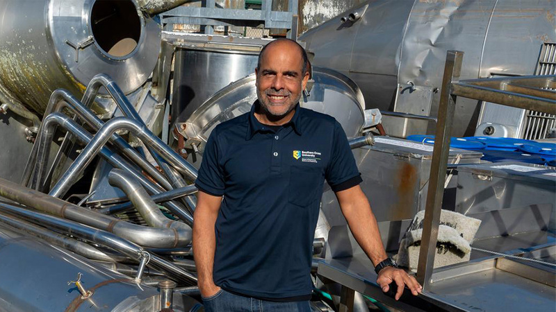Portrait of Dirk Erler in front of machinery