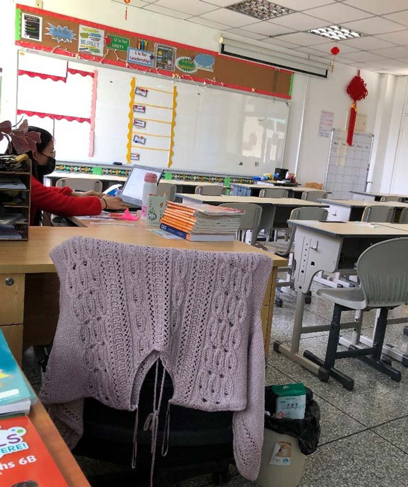 A schoolteacher works in an empty classroom