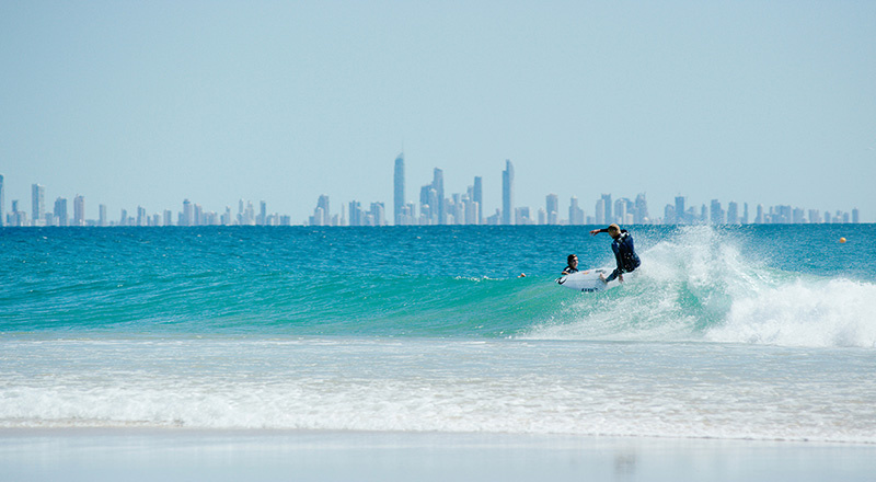 Mick-Fanning-surfing-on-Coolangatta-beach-with-city-skyline