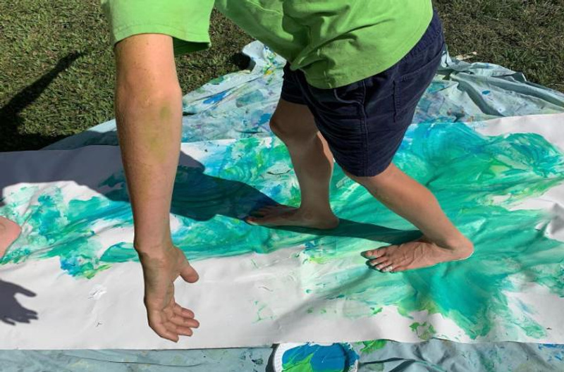 Young student painting with feet