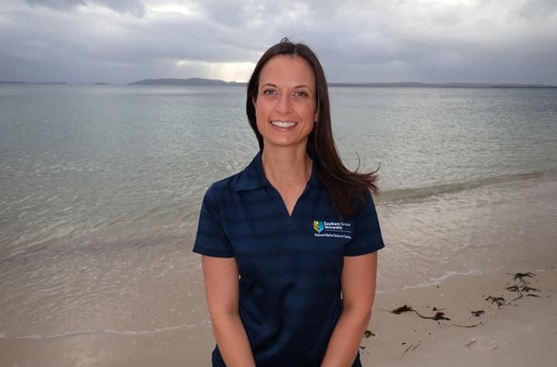 Woman in front of an ocean wearing a SCU-logo polo
