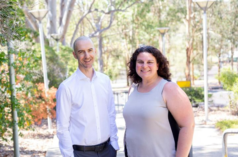A man and woman standing in front of gum trees