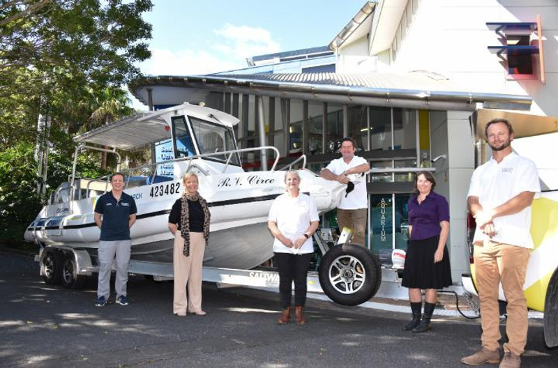 A group of 6 people standing alongside a vessel called RV Circe