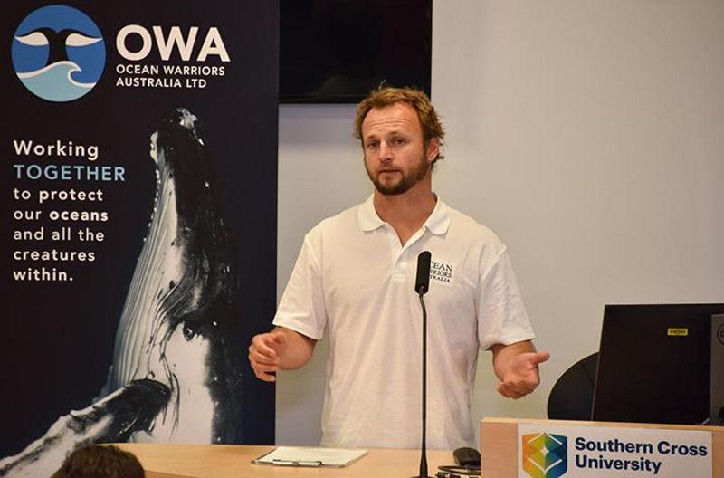 Man in white polo shirt making a presentation