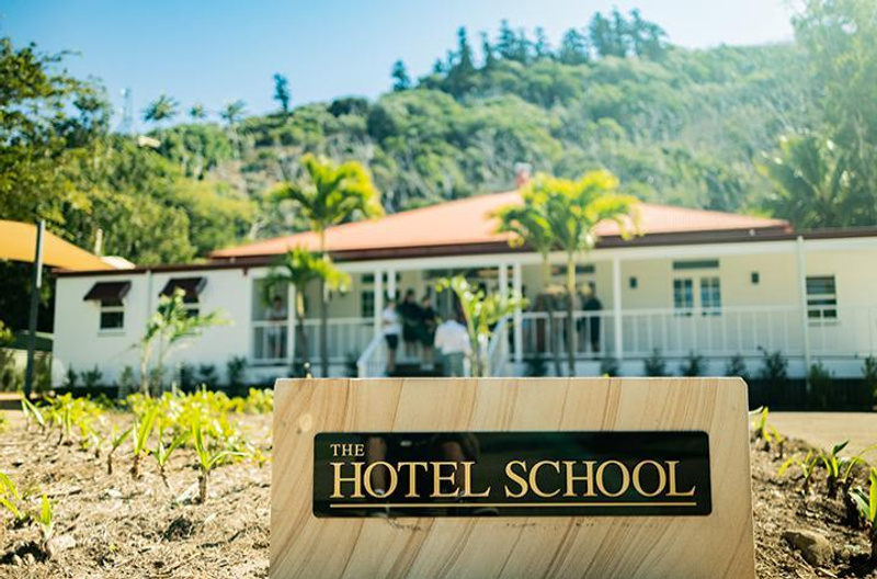 The Hotel School sign outside a building