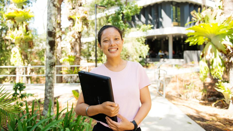 Female student portrait on Lismore campus with folder