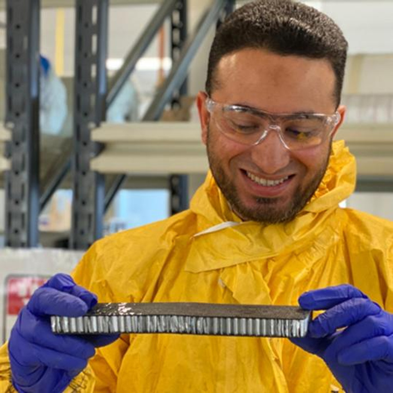 Man smiling wearing protective goggles in laboratory