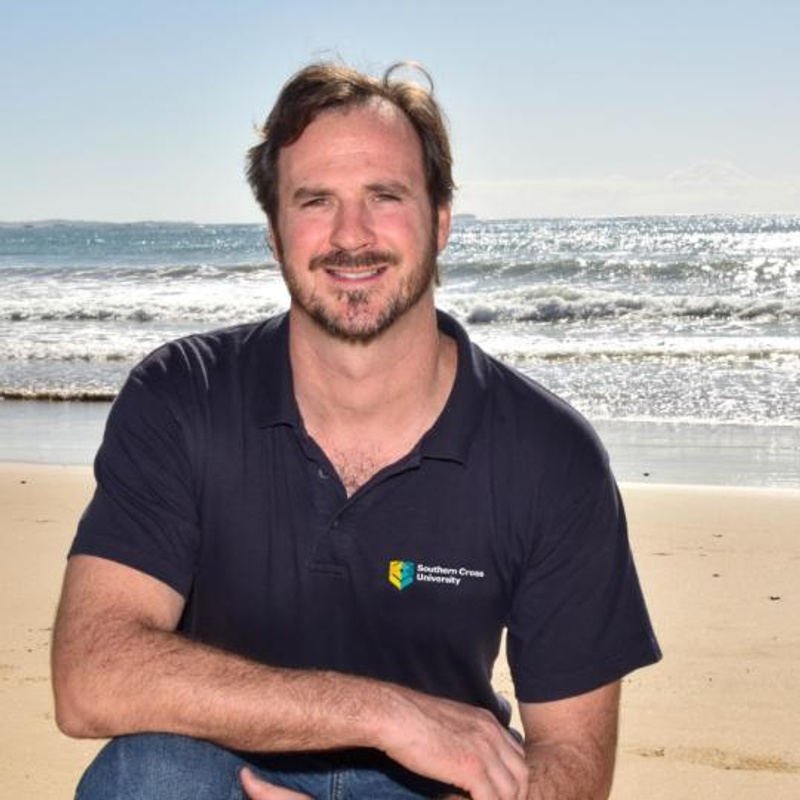 Man smiling with beach in background