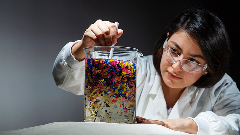 researcher examining plastics in beaker