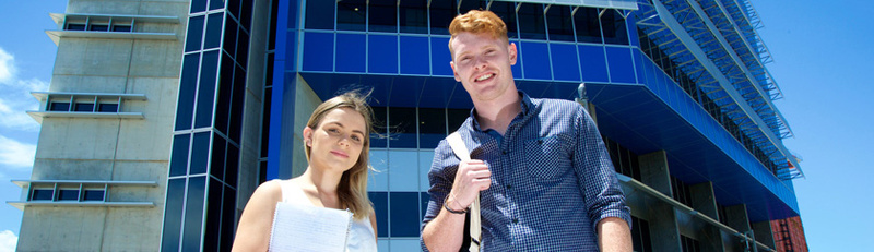 Male and female student ambassadors stading in front of SCU Gold Coast building 