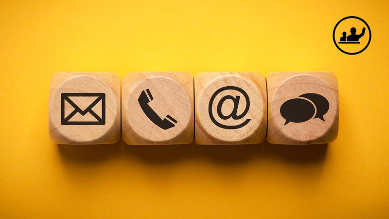 envelope, phone, at, speech bubble and student symbols on wooden dice on yellow background