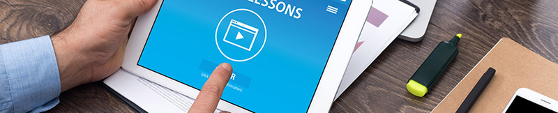 banner image of hands holding a phone with a video playing on the screen and laptop in the background