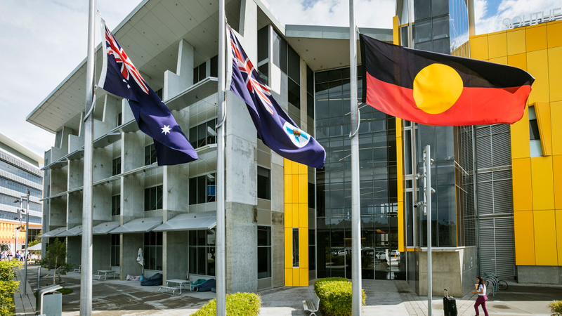 Gold Coast campus building with flags in foreground