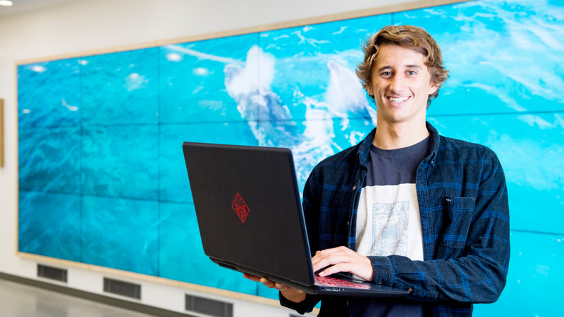 Information Technology student Josh Clouston with laptop on Gold Coast campus